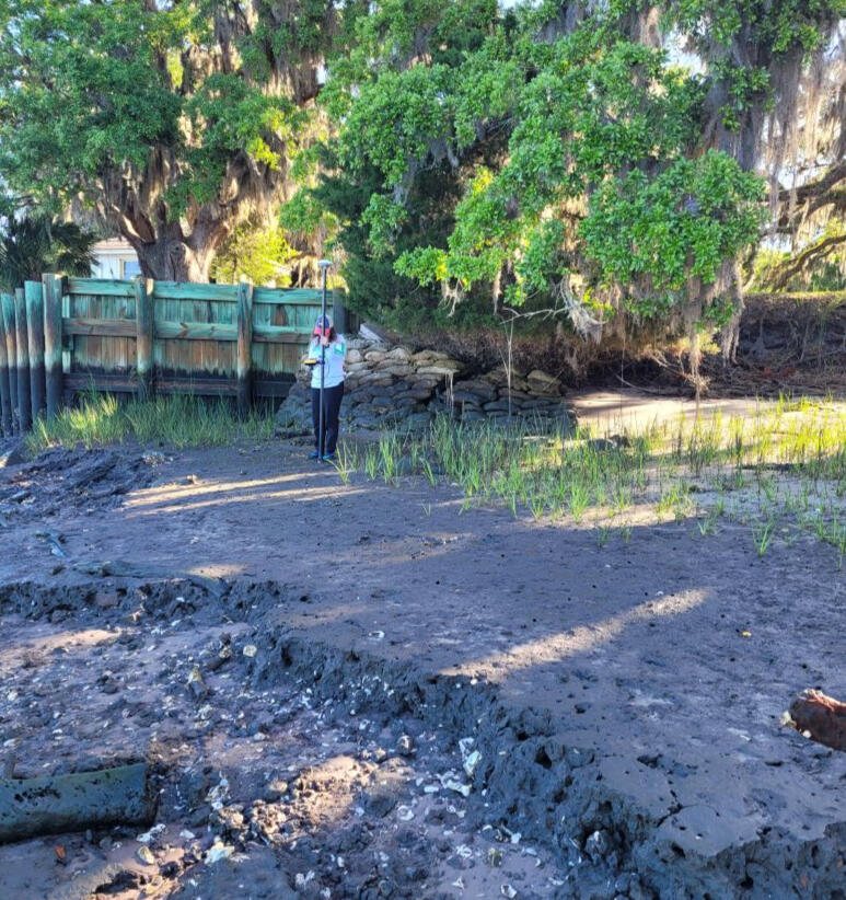 Photo of Denise Wright using a Trimble GPS to measure shoreline change.
